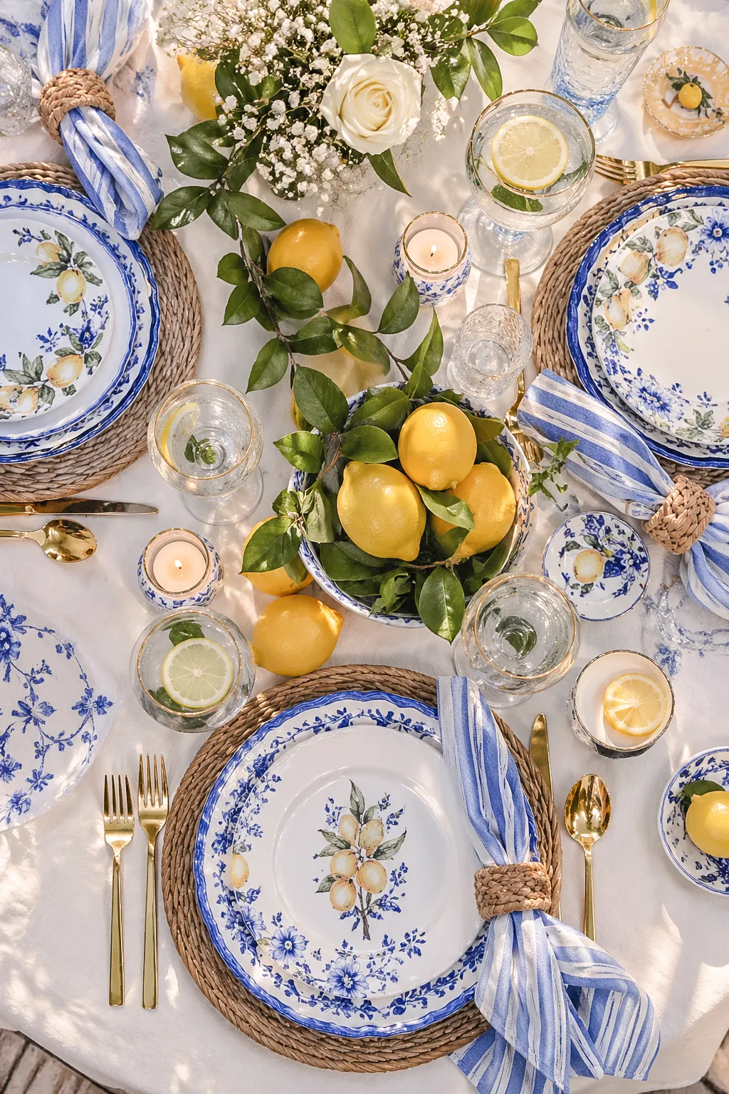 Blue and white La Dolce Vita bridal shower table setting with rattan placemats, striped napkins and lemons